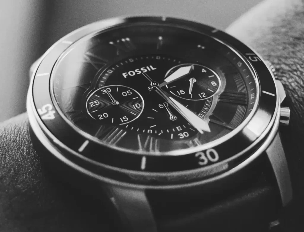 Close-up of a Fossil watch's crystal on a man's wrist.