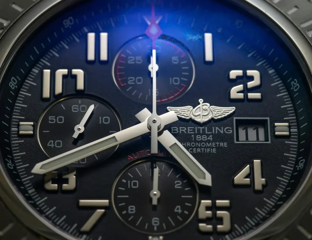 Close-up of a Breitling watch dial, featuring hands, a date window, and three sub-dials.