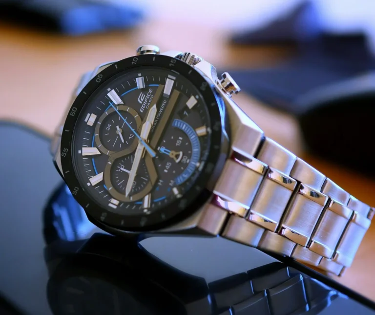 A stylish silver Casio watch resting on a modern black table.