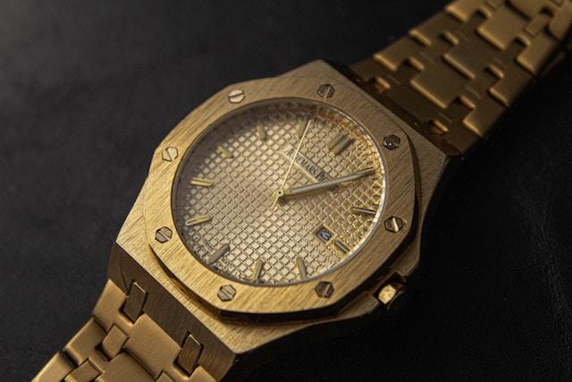 Close-up of a gold Audemars Piguet watch with an integrated bracelet, showcasing its luxurious design.