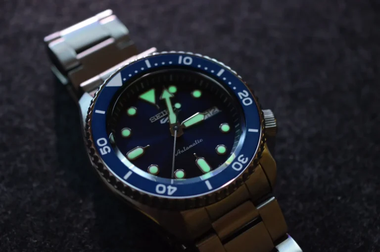 Close-up of Seiko dive watch with luminous hands and indices.