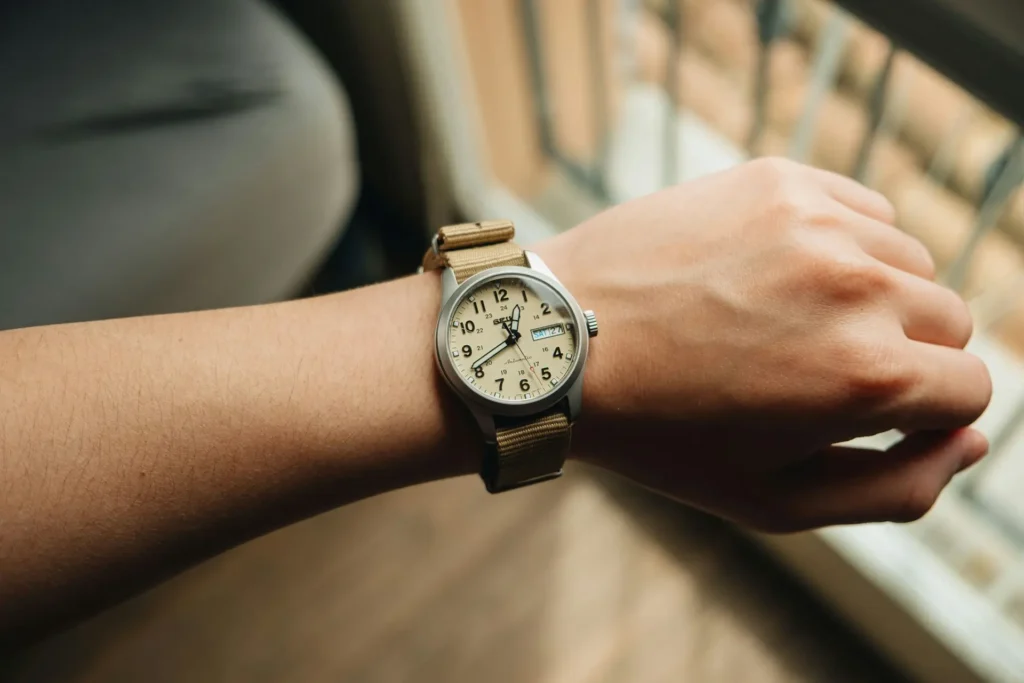 A person wearing a Seiko 5 watch on a wrist.