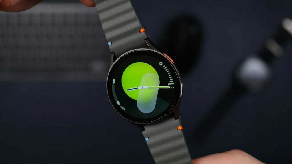 A person is holding a smart watch featuring a vibrant green face.