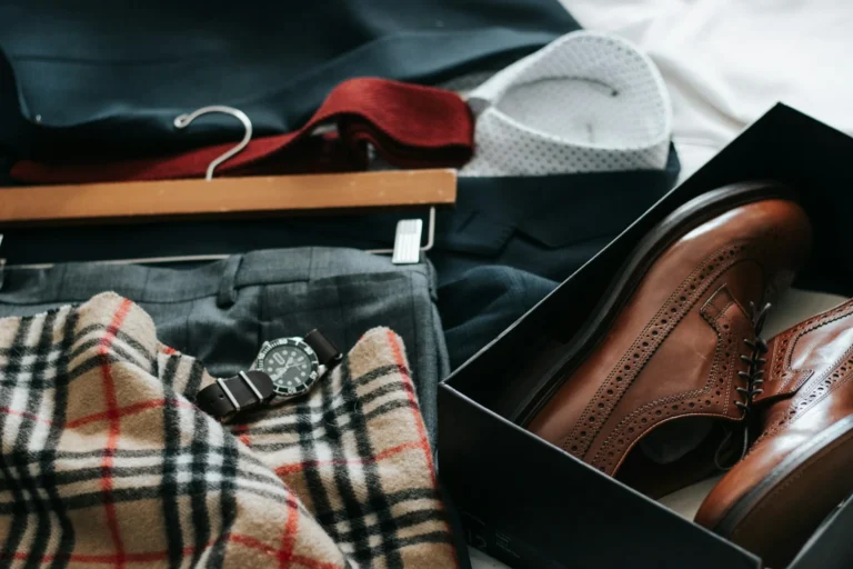 A stylish wardrobe featuring a pair of shoes, a watch, and a plaid shirt.