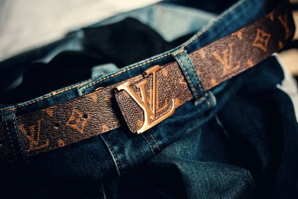 A Louis Vuitton belt rests stylishly on a pair of jeans.