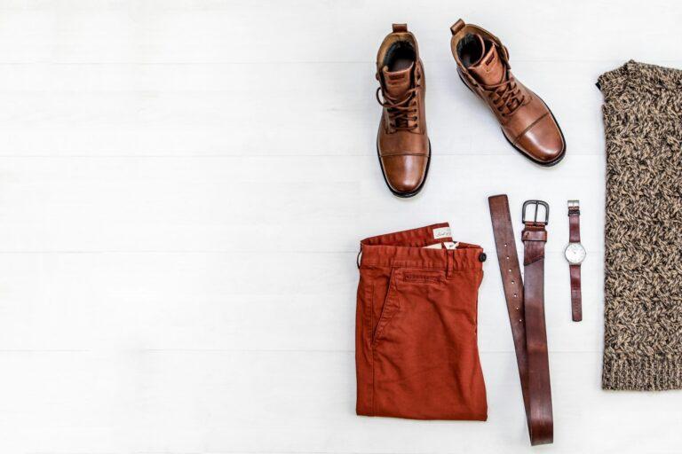 A man's outfit displayed on a white wooden floor, featuring coordinated accessories, including a stylish belt.