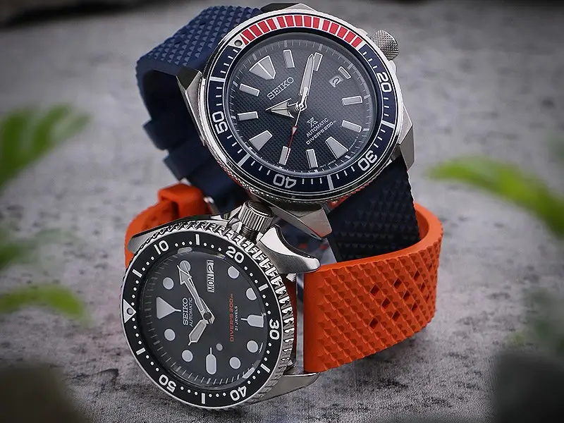 Two Seiko watches with blue and orange Rubber straps