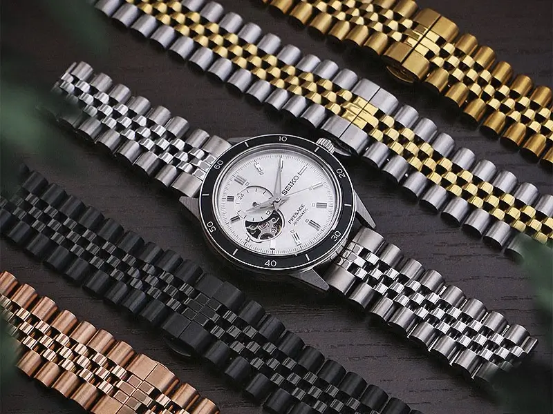 Five stainless steel watch bracelets, each with a different finish