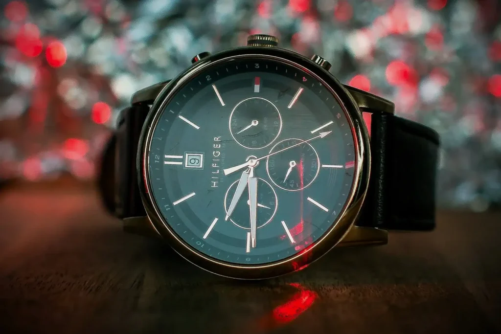 Close-up of a Tommy Hilfiger watch featuring three subdial and a leather strap, resting on a wooden table