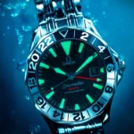 Close-up of an Omega Seamaster GMT underwater with luminous indices and hands