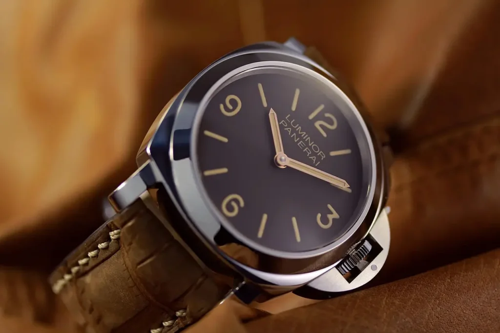 Close-up of a Panerai Luminor dress watch with a brown leather strap.