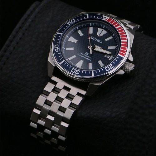 A Seiko automatic watch with an Engineer bracelet, displayed on a textured black background.